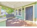 Inviting front porch with a wooden swing, providing a relaxing outdoor space at 213 W Cayuga St, Tampa, FL 33603