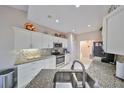 Bright kitchen with granite countertops, stainless steel appliances, and white cabinetry at 2337 Platinum Dr, Sun City Center, FL 33573
