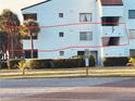 Exterior shot of condo building with palm trees, green grass, and building number clearly displayed at 2593 Countryside Blvd # 7213, Clearwater, FL 33761