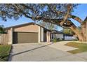 Ranch style home with a large oak tree and driveway at 3911 King Dr, Brandon, FL 33511