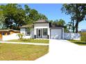 Inviting single-story home with white exterior, lush lawn, and attached garage at 408 E Hanlon St, Tampa, FL 33604