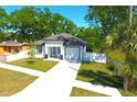 Well-maintained single-story home with a lush lawn, white exterior, and attached garage at 408 E Hanlon St, Tampa, FL 33604