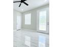 Bright, airy living room with elegant marble floors, modern ceiling fan, and ample natural light at 408 E Hanlon St, Tampa, FL 33604