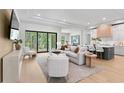 Bright, open living area flows into the kitchen, featuring modern furnishings, sleek floors, and expansive sliding glass doors at 10639 Ruffino Ct, Trinity, FL 34655
