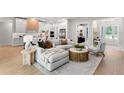 Bright, open living space features a comfortable sectional, modern decor, and seamless flow to the kitchen at 10639 Ruffino Ct, Trinity, FL 34655