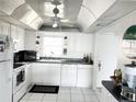 White kitchen with vaulted ceiling, ample counter space, and appliances at 4525 Cove Cir # 1002, St Petersburg, FL 33708