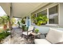 Covered porch with stone tile flooring, comfortable seating, and potted plants at 5901 1St Ne St, St Petersburg, FL 33703