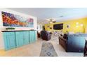 Bright living room with teal cabinet, large TV, and comfy seating at 6888 121St N St, Seminole, FL 33772