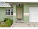 Light beige front door and small porch with landscaping at 807 Leffingwell Ave, Ellenton, FL 34222