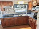 Galley kitchen with wood cabinets and tile backsplash at 9790 66Th N St # 330, Pinellas Park, FL 33782