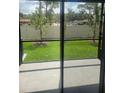 View of backyard, highlighting the patio, green lawn, and privacy fence at 11851 Davis Dr, Largo, FL 33774