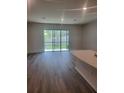 Spacious living room featuring hardwood floors and large sliding glass doors to backyard at 11851 Davis Dr, Largo, FL 33774