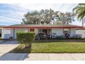 Ranch style home with red roof and lush landscaping at 1809 Chinaberry Dr, Oldsmar, FL 34677