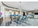 Bright dining room features a modern chandelier, sleek table with seating for eight, and a view of the updated kitchen at 20001 Gulf Blvd # 501, Indian Shores, FL 33785