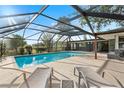 Inviting swimming pool with a screened enclosure and lounge chairs at 2374 Conway Blvd, Port Charlotte, FL 33952