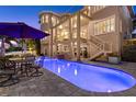 Stunning backyard with a large, illuminated pool, patio seating, and an elegant multi-story home at 6015 Kipps Colony E Dr, Gulfport, FL 33707