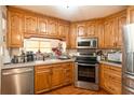 Traditional kitchen featuring oak cabinets, stainless steel appliances and hardwood floors at 6726 S Sheridan Rd, Tampa, FL 33611