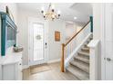Bright foyer with wood floors, staircase, and decorative chandelier create a welcoming entrance at 14672 Horse Trot Rd, Lithia, FL 33547
