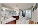 Modern bathroom featuring a double sink vanity, marble countertop, and a glass-enclosed shower at 1957 Whitney Oaks Blvd, Clearwater, FL 33760