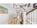 Bright entryway featuring wood floors, a staircase, and elegant wall art at 1957 Whitney Oaks Blvd, Clearwater, FL 33760