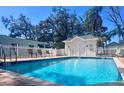 Community pool is surrounded by a white picket fence and mature landscaping at 1957 Whitney Oaks Blvd, Clearwater, FL 33760