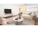 Living room features hardwood floors, stylish furniture, and a large TV at 23315 Charlston Pl, Land O Lakes, FL 34639