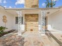 Front entry with stonework, ornate columns, and tile flooring at 529 80Th Ave, St Pete Beach, FL 33706