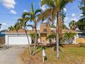 Single-story home with white exterior, attached garage, and landscaping at 529 80Th Ave, St Pete Beach, FL 33706