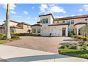 Two-story townhome with a brick driveway and palm trees at 10043 Crooked Creek Dr # 101, Venice, FL 34293