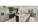 Modern kitchen with dark cabinets, stainless steel appliances, and an island at 10911 Gentle Current Way, Parrish, FL 34219