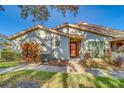 Front view of a charming villa with a red door and walkway at 2035 Nash Dr, Clearwater, FL 33763