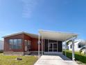 Exterior view of home with a covered carport and screened in patio on a sunny day at 225 N Saint Thomas Cir, Apollo Beach, FL 33572