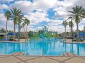 Resort-style pool with a water playground, palm trees, and lounge areas at 22547 Storybook Cabin Way, Land O Lakes, FL 34637