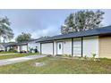 Single-story home with white exterior, attached garage and covered entryway at 22702 Penny Loop, Land O Lakes, FL 34639
