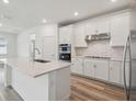 Bright kitchen featuring white cabinets, stainless appliances and quartz countertops at 4202 Big Sky Dr, Spring Hill, FL 34604