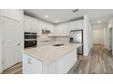 Modern kitchen with white cabinets, stainless steel appliances, and a large center island at 4202 Big Sky Dr, Spring Hill, FL 34604