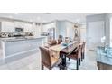 Stylish dining room adjacent to a modern kitchen with granite countertops and stainless steel appliances at 5513 Rainwood Meadows Dr, Apollo Beach, FL 33572