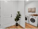 Bright laundry room featuring modern washer and dryer units, with stylish decor and wood flooring at 600 3Rd S Ave # 401, St Petersburg, FL 33701