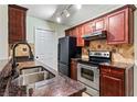 Well-lit kitchen features stainless steel appliances, granite countertops, and stylish backsplash at 10263 Gandy N Blvd # 107, St Petersburg, FL 33702