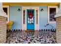 Quaint front porch featuring a mosaic tile floor and a bright blue door at 115 Athens St, Tarpon Springs, FL 34689