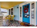 Inviting front porch with colorful mosaic tile and wicker chairs at 115 Athens St, Tarpon Springs, FL 34689