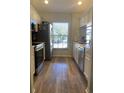 Bright kitchen with stainless steel appliances and wood-look flooring at 4220 Players Pl # 2221, Sarasota, FL 34238