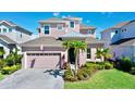 Two-story house with a light pink exterior, gray roof, and palm trees at 5221 Wishing Arch Dr, Apollo Beach, FL 33572