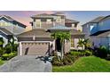 Two-story house with a light pink exterior, gray roof, and palm trees at 5221 Wishing Arch Dr, Apollo Beach, FL 33572