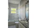 Elegant bathroom featuring granite vanity, shower over tub with glass screen and marble tile at 122 W Sligh Ave, Tampa, FL 33604