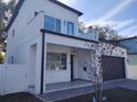 Modern two-story home with stucco exterior, covered entry, and glass balcony railing at 122 W Sligh Ave, Tampa, FL 33604