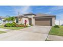 House exterior with landscaping and a two-car garage at 12712 Weston Oaks Ln, Riverview, FL 33579