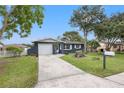 Newly renovated home with gray exterior, white garage door, and a mailbox at 15111 Verona Ave, Clearwater, FL 33760