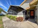 Charming front porch with a screened-in enclosure, beautiful landscaping, and a welcoming entrance at 2281 Lake Arbor Blvd, Clearwater, FL 33763