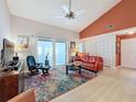 Cozy living room with a ceiling fan, sliding glass doors, and a pop of color from the accent wall and rug at 2281 Lake Arbor Blvd, Clearwater, FL 33763